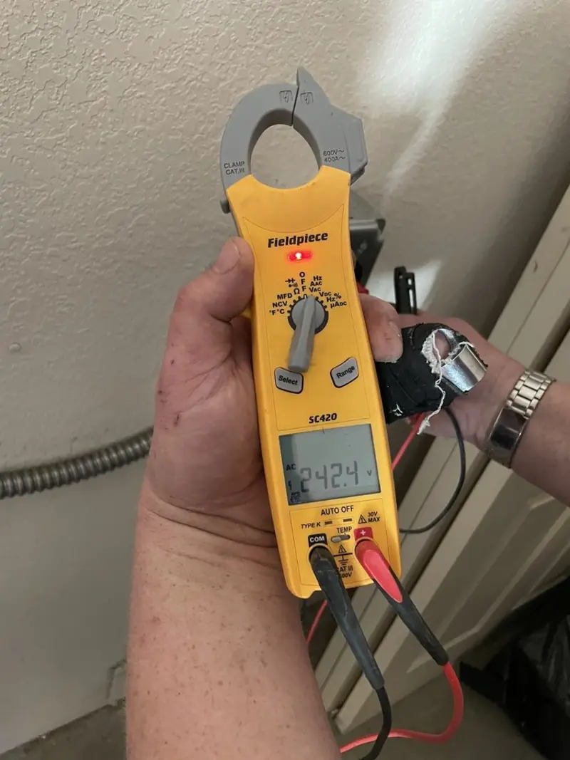 Voltage testing with clamp meter during Whole House Surge Protector in Paris